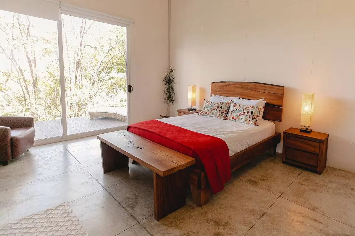 Bedroom one with hardwood bed and glass doors to the deck